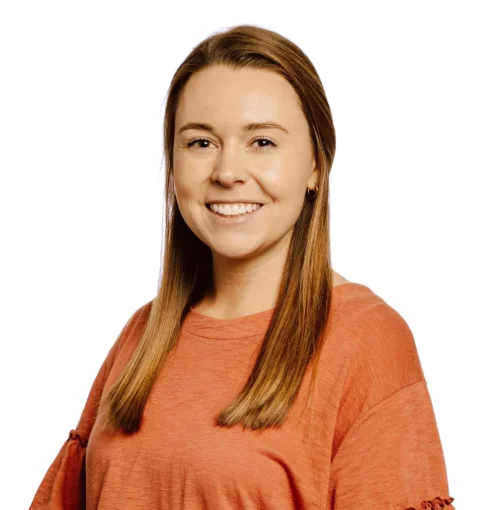 a woman in an orange shirt smiling at the camera