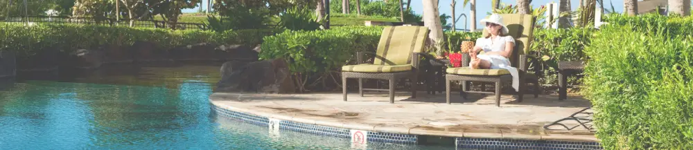 a woman sitting on a chair next to a pool