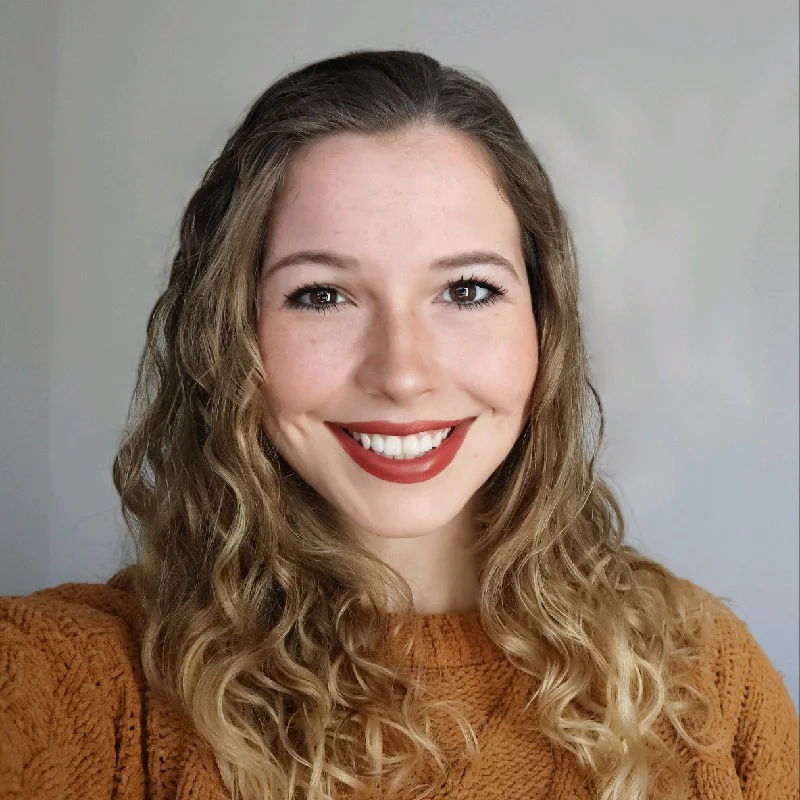 a woman with long blonde hair and a smile on her face