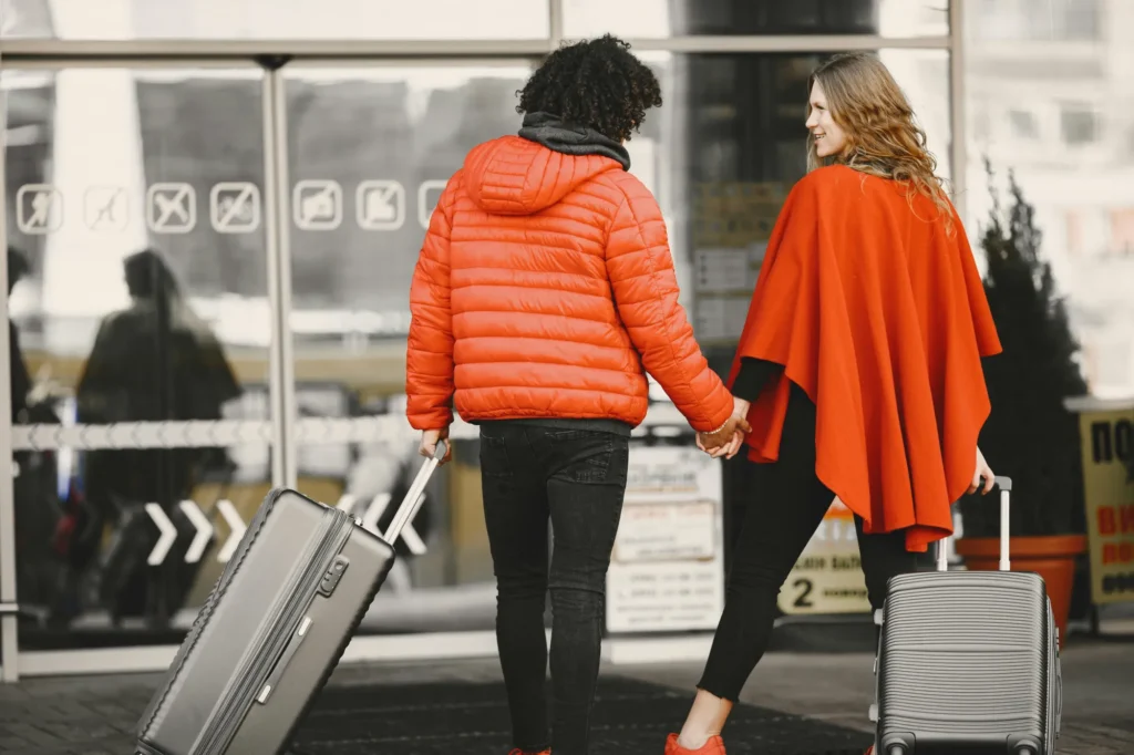 a couple of women walking down a street with luggage