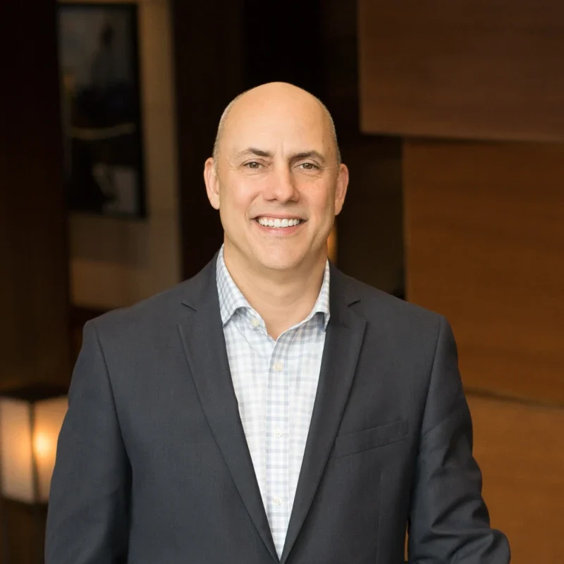 a man in a suit smiling for the camera